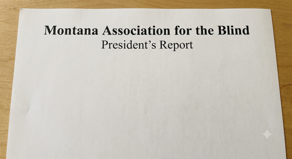 A document on a wooden desk, with Montana Association for the Blind President's Report at the top.